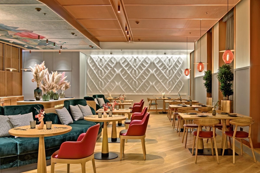 Интерьер ресторана с «вязаной» стеной и репродукцией знаменитой картины на потолке